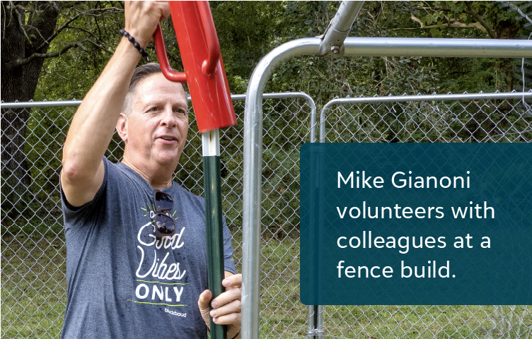 Mike Gianoni volunteers with colleagues at a fence build.